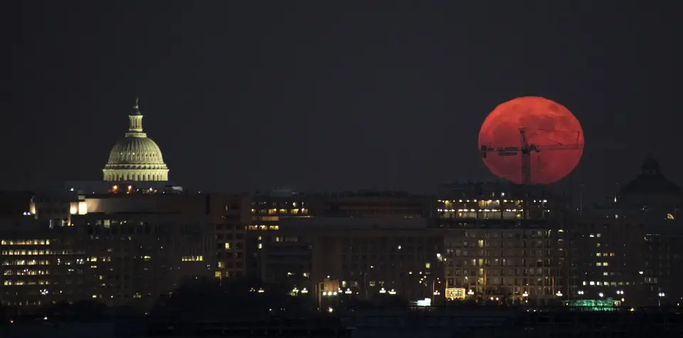 A large full Moon rising above the Washington skyline.