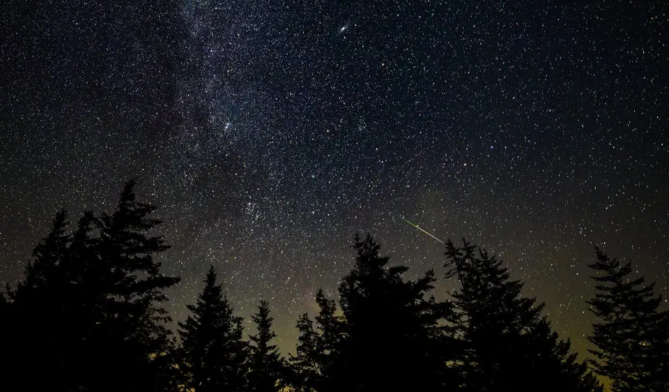 A meteor streaks across the night sky.